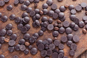 Dark Chocolate Drops on Wooden Background