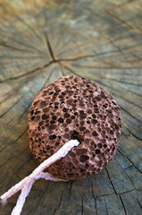 pumice stone with a cord on old wooden background