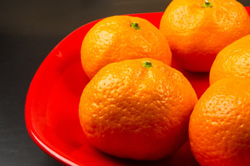 tangerines in a red plate