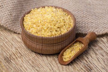 Raw Bulgur (on wooden background)