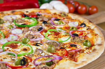 Tuna Pizza onions, olives, bell pepper on wooden background