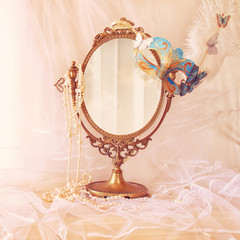 Obraz premium blue venetian mask next to old vintage oval mirror