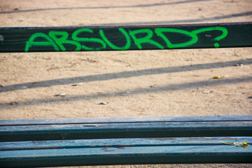Old bench with Absurd graffiti on it, Paris, France