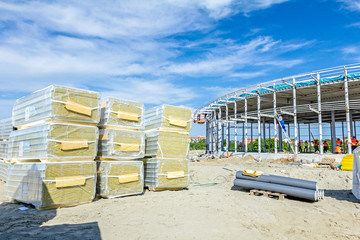 Stack of insulation composite panel walls are piled on building
