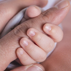 Baby hand holding father's finger