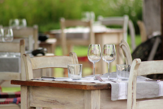  Table de restaurant gastronomique en terrasse avec verres à vin et couverts