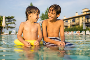 Fototapeta premium Young boy kid child splashing in swimming pool having fun leisur