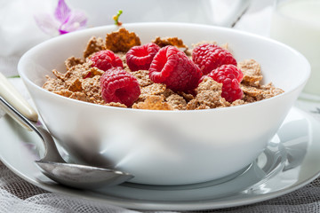 Tasty breakfast with milk and raspberries.