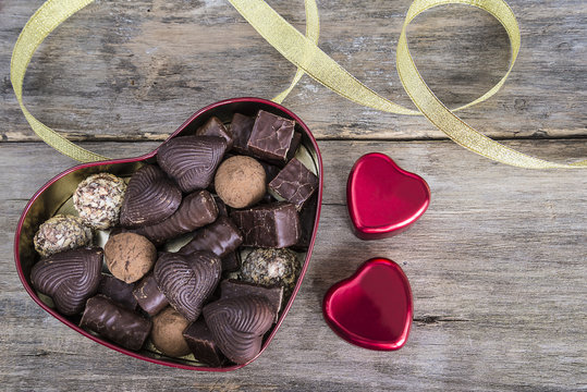 valentine's day concept/box shaped heart of chocolates on old wooden background