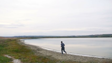 runner athlete in a sports man suit runs on the nature of the landscape