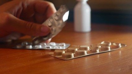 pills on a table cold disease flu medicine video man puts on the table thermometer