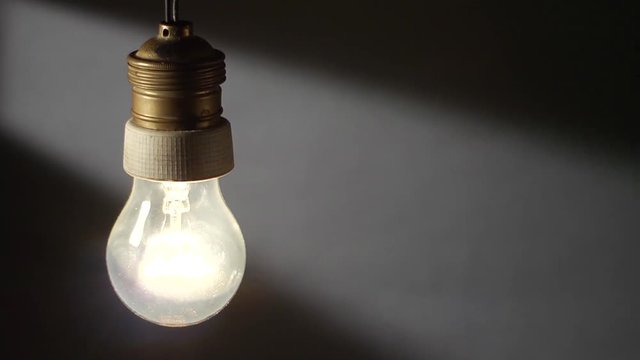 Una vecchia lampada al tungsteno, si accende e si spegne lentamente.