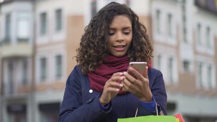Stylish woman looking for clothes, actively surfing online stores on smartphone