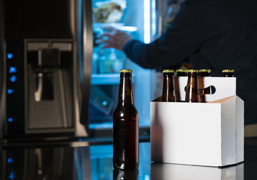 Six pack of brown beer bottles on kitchen counter