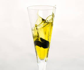 Olive Oil splashing over stemware