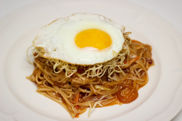 American Chop Suey with Chicken is an Indo-Chinese dish served on a bed of noodles topped with fried noodles and an egg