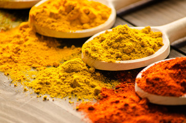 Spilled powder spices and wooden spoons -Close up