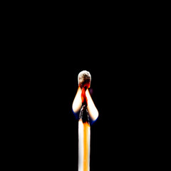 Used match and flame with black background