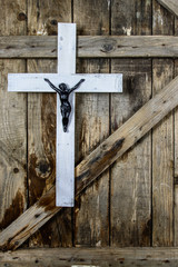Wooden white cross on old wooden wall