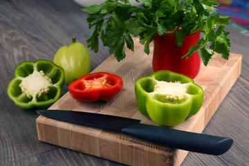 sliced sweet peppers with a ceramic knife on a wooden board