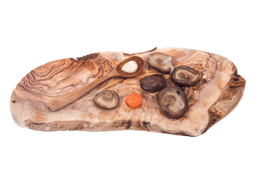 Shiitake marinated mushrooms with wooden spoon on olive wood cutting board