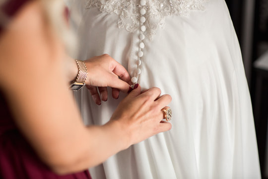 Wedding dress, preparation of bride at wedding day. Bridesmaid help dresses bridal dress