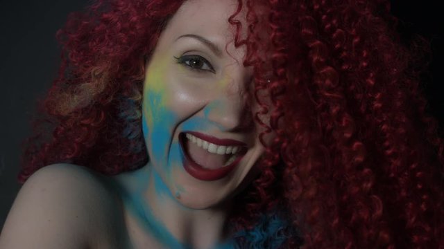 4k shoot of a redhead girl in studio smiling and shaking hairs
