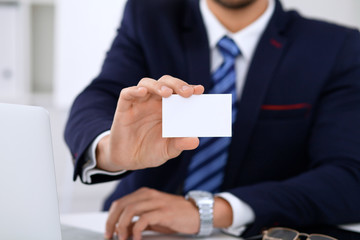 Close up of  businessman or lawyer  giving a business card while sitting at the table. He offering partnership and success deal