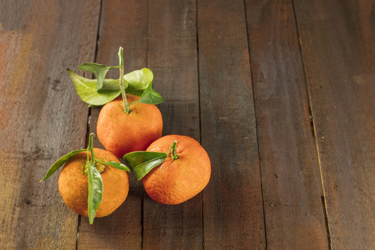 Tangerines on rustic wooden texture with copyspace