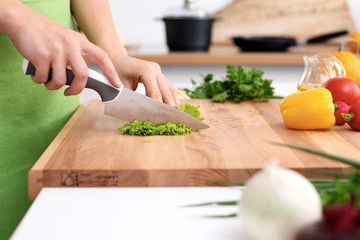 Close up of  woman's hands cooking in the kitchen. Housewife slicing ​​fresh salad. Vegetarian and healthily cooking concept