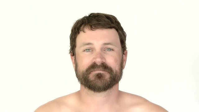 Model released man in studio with beard looking at camera smiling. Captured in 4K.