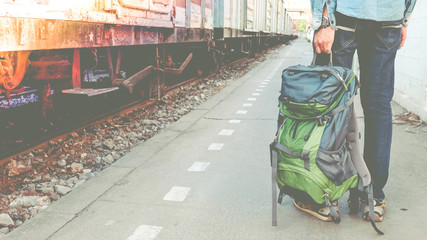 Backpacker waiting for long gourney travel at train station with backpack. Travel concept with...
