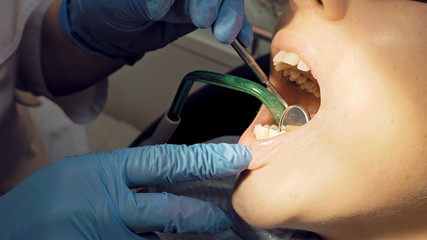 Woman at the dentist clinic office gets dental medical examination and treatment. Close up shot. Odontic and mouth health is important part of modern human life that dentistry help with.