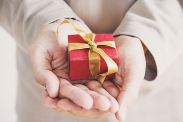 A man hand holding red little gift box on hand,isolated on white background