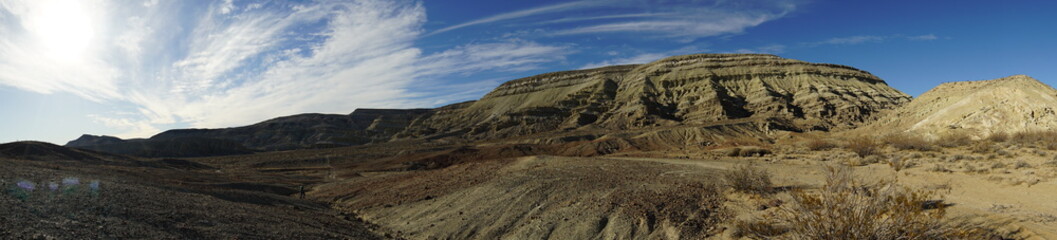 a butte is featured in a desert panorama.