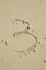 Fototapeta na wymiar Numbers written on the sand