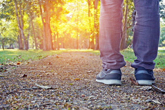 man legs walking in a park with beautiful nature sunset background