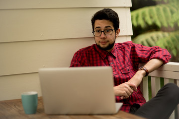Young man with a laptop and smartphone sitting outdoor