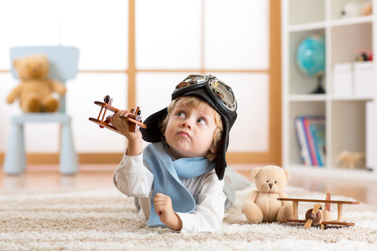 Child boy playing with toy airplane and dreaming of becoming a pilot