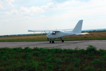 Small sport aircraft on the runway at the airport.