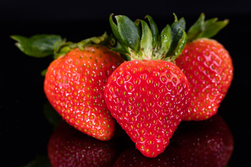 Three strawberries isolated on black