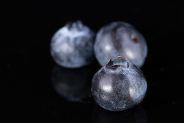 Three blueberries isolated on black