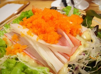 Crab sticks and shrimp eggs salad in glasses bowl