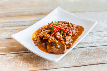 Beef in ground peanut coconut cream curry on white plate