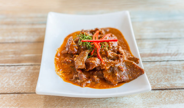 Beef in ground peanut coconut cream curry on white plate
