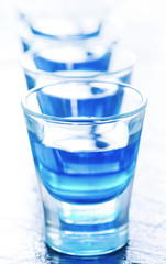 blue alcoholic drink into small glasses