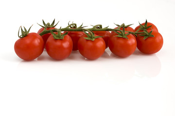 Bunch of cherry tomatoes on white background. Still-life picture taken in studio with soft-box.
