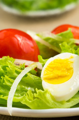 Boiled egg, lettuce and juicy red cherry with onions