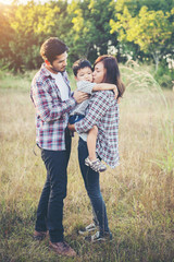 Happy young family spending time together outside in green natur