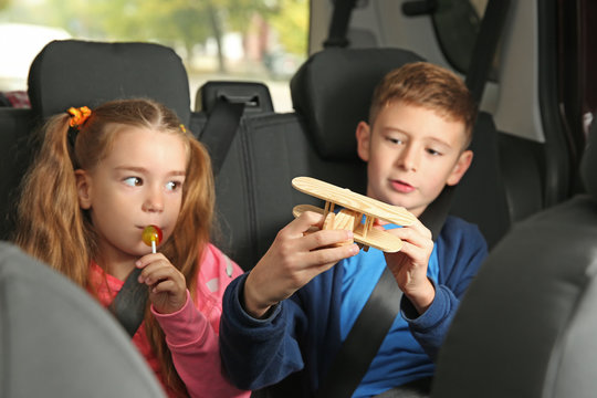 Cute children in car on backseat